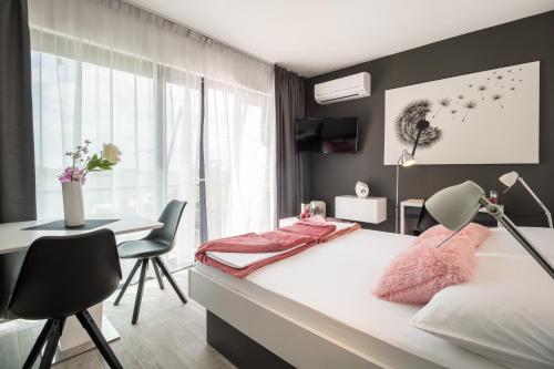 a bedroom with a bed and a desk and a table at Residence Alpha Apartments in Cavtat