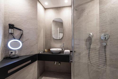 a bathroom with a sink and a shower at Strasserwirt - Ansitz zu Tirol in Strassen