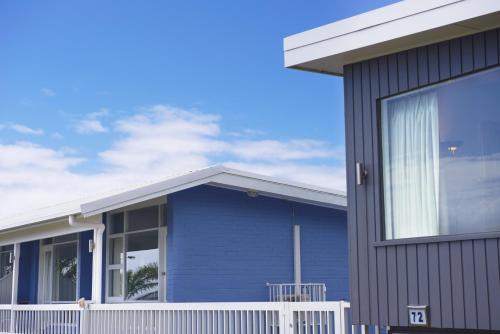 a blue house with a white fence in front of it at Harbour View Apartments in Ulladulla