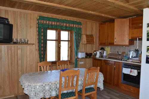 a kitchen with a table and chairs and a window at Bērziņi in Vitrupe