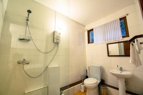 een badkamer met een douche, een toilet en een wastafel bij YK Art House in Phnom Penh