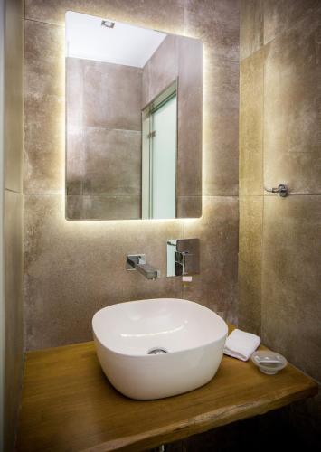 a bathroom with a white sink and a mirror at Il Grigio Apartments in Limenaria