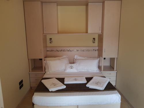 ザンブローネにあるLa Rosa dei Ventiのベッド2台と白いキャビネットが備わる小さな客室です。