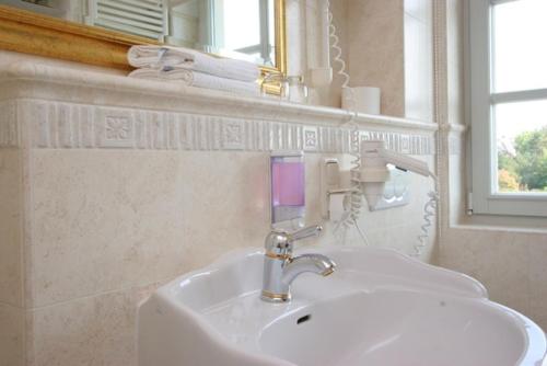 ein Badezimmer mit einem weißen Waschbecken und einem Spiegel in der Unterkunft Haus am Kiel in Ahrenshoop