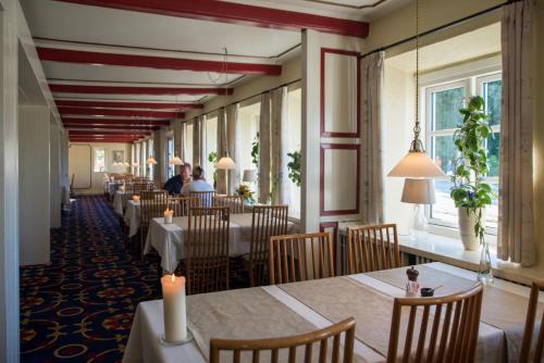 een restaurant met tafels en stoelen en mensen die er zitten bij Hotel Aarslev Kro in Brabrand