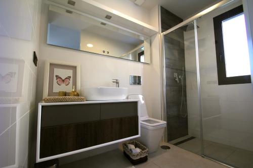 een badkamer met een wastafel, een douche en een toilet bij Casa Laura in Playas de Orihuela