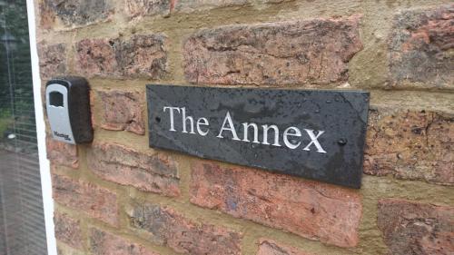 a sign on a brick wall with the amway on it at Aiskew Villa Annex in Bedale