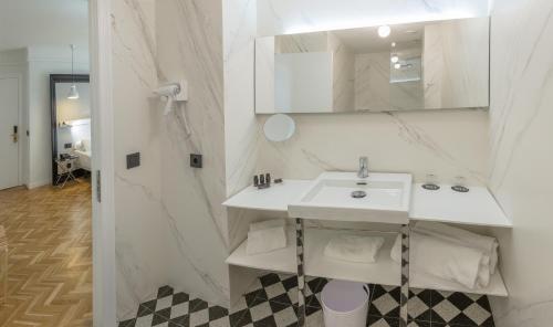 a white bathroom with a sink and a mirror at SH Ingles Boutique Hotel in Valencia