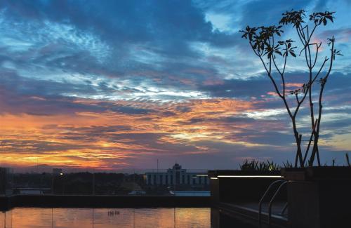 a view of a sunset from a balcony of a city at Golden Tulip Essential Tangerang in Tangerang