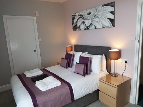 a bedroom with a large bed with purple pillows at Grosvenor House Hotel in Torquay