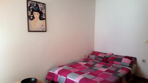 a bed in a room with a picture on the wall at Holiday Home Ana in Prvić Luka