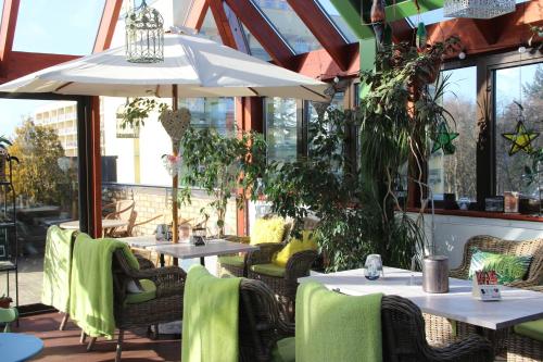 a restaurant with tables and chairs and an umbrella at SeaPark Hotel Wellness & Spa in Kołobrzeg