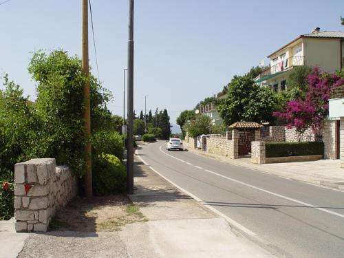 a street with a car parked on the side of the road at Apartments Losinj in Mali Lošinj