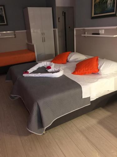 a large bed with orange and white pillows on it at Vila Marija in Skradin