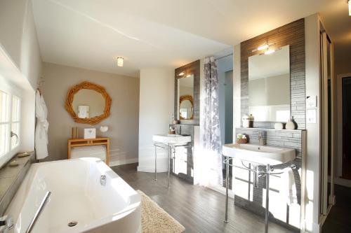 een badkamer met 2 wastafels en een bad bij Villa La Tosca in Lanton