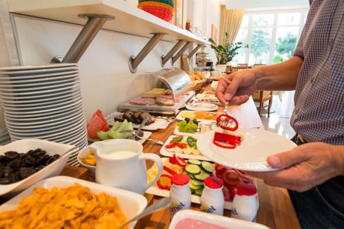 um homem a preparar comida num balcão com pratos de comida em Seehotel Paulitsch em Velden am Wörthersee