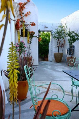 un patio con tavolo, sedie e piante di Il Giardino a Grottaglie