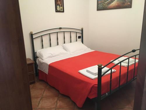 a bedroom with a bed with a red blanket at Appartamenti e Camere Il Poggio di D'Angeli Lidia in Auditore