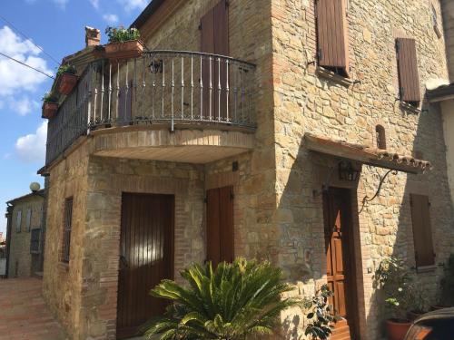 a stone building with a balcony on top of it at Appartamenti e Camere Il Poggio di D'Angeli Lidia in Auditore