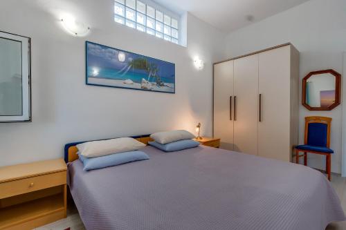 a bedroom with a bed and a blue chair at Holiday home Nikol in Veli Lošinj