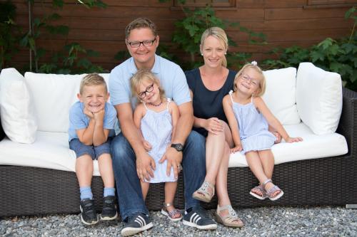 a family is sitting on a couch at Seilers Vintage Hotel & Spa in Kandersteg