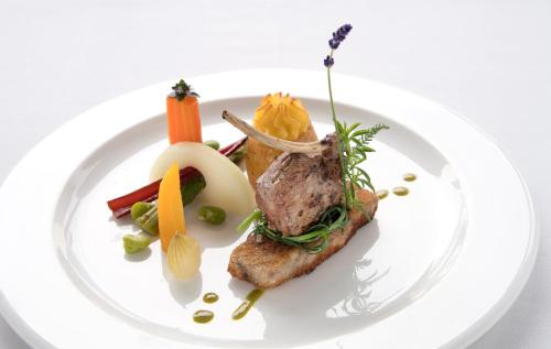 a plate of food with meat and vegetables on it at Seilers Vintage Hotel & Spa in Kandersteg