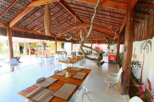 a pavilion with tables and chairs in a restaurant at Village Muta in Porto Seguro