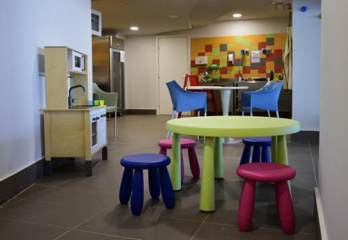 a brightly colored table and stools in a kitchen at Saracen Sands Hotel & Congress Centre - Palermo in Isola delle Femmine