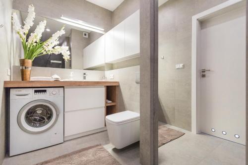 a bathroom with a washer and dryer in a room at InPoint Downtown Apartments near Old Town in Krakow