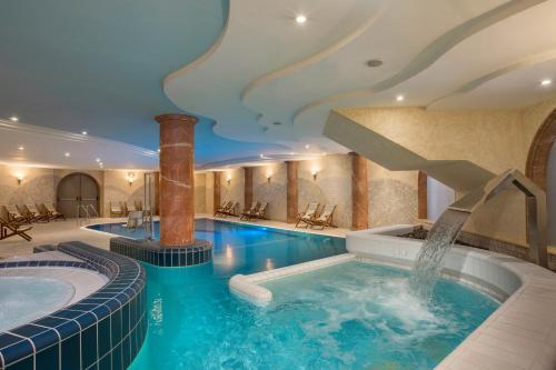 a pool in a hotel with a staircase in the ceiling at Gai Beach Hotel in Tiberias