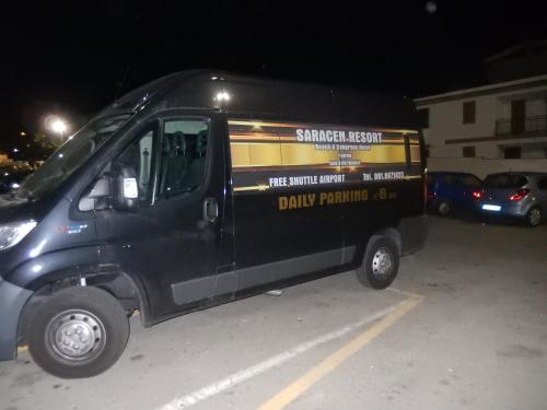 a black van parked in a parking lot at night at Saracen Sands Hotel & Congress Centre - Palermo in Isola delle Femmine