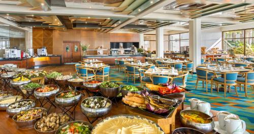 a buffet of food in a restaurant with tables and chairs at Gai Beach Hotel in Tiberias