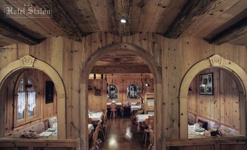 une salle à manger avec des murs en bois et deux arches dans l'établissement Hotel Stalon Alpine Chic, à San Martino di Castrozza