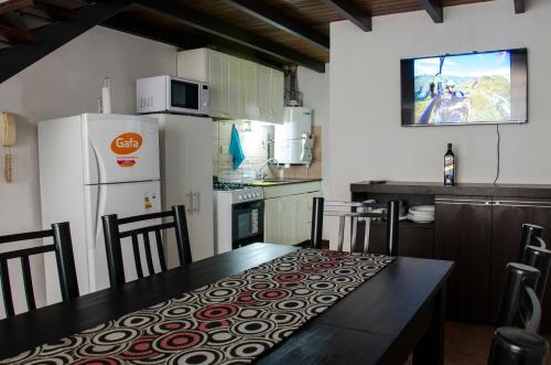 a kitchen with a dining table and a refrigerator at Departamento Loft, en medio de la ciudad in Mendoza