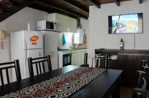 cocina con mesa de comedor y nevera en Departamento Loft, en medio de la ciudad en Mendoza