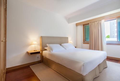 ein Schlafzimmer mit einem großen weißen Bett und einem Fenster in der Unterkunft 6001 by RMC in Funchal