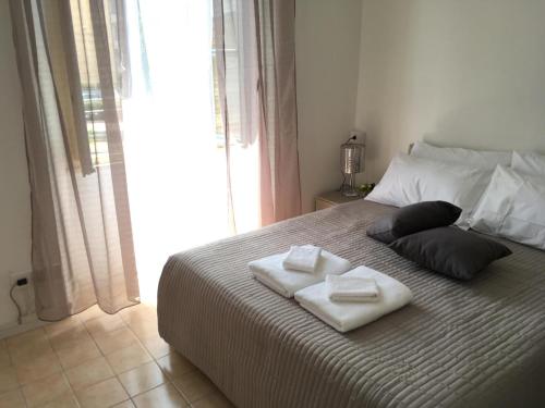 un letto con due asciugamani e cuscini sopra di Orchidea in Centro a Como