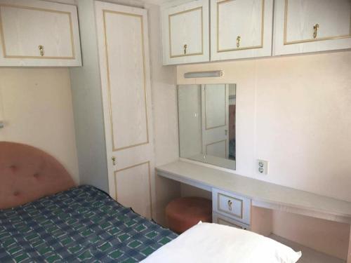 a small room with a bed and a mirror at Paradiset Östra Öland in Nedra Sandby