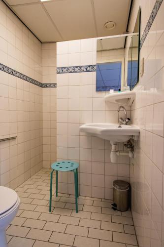 a bathroom with a sink and a toilet and a stool at Hotel Restaurant Taverne in Twello