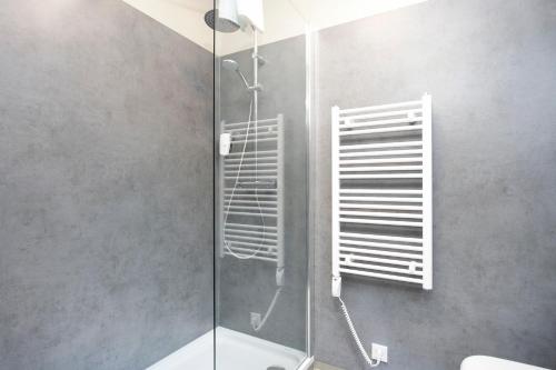 una ducha con puerta de cristal en un baño en Arnarstapi Hotel, en Stapi