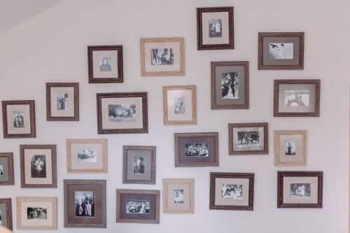 a wall of framed pictures on a wall at Pensiunea Vis Alpin Belis in Beliş