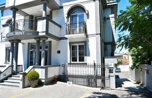 a white building with a gate in front of it at Garni Hotel Mint in Belgrade