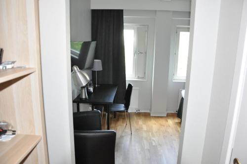 a living room with a table and chairs at City Hotel in Kristinehamn