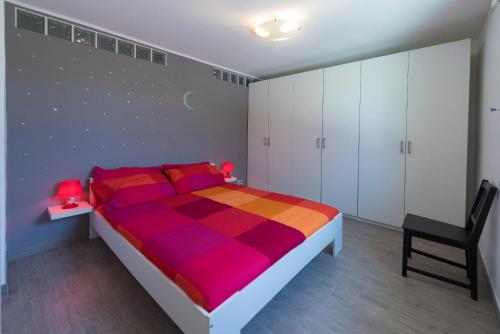 フィナーレ・リーグレにあるCasa Ettoreのベッドルーム(カラフルなベッド1台、椅子付)
