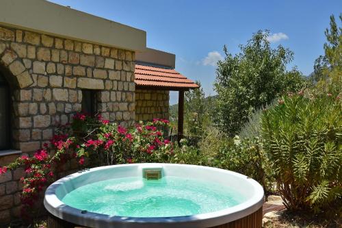 a bath tub in a garden next to a building at Zimmers at the Forest in Amirim