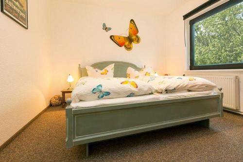 ein Schlafzimmer mit einem Bett mit Schmetterlingen drauf in der Unterkunft RügenHerz Piratenhaus in Parchtitz