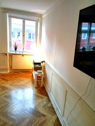 a living room with a television and a table with a lamp at Central Danish apartment in Copenhagen