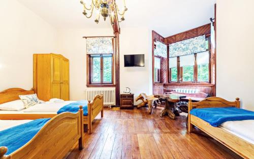 a bedroom with three beds and a chandelier at Apartamenty EverySky - Willa Grota in Karpacz