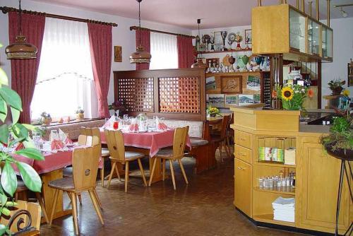 ein Esszimmer mit einem Tisch und Stühlen sowie eine Küche in der Unterkunft Gasthaus und Pension Hintere Höfe in Freiamt