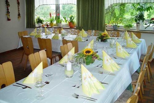 una mesa larga con sombrillas amarillas. en Gasthaus und Pension Hintere Höfe, en Freiamt
